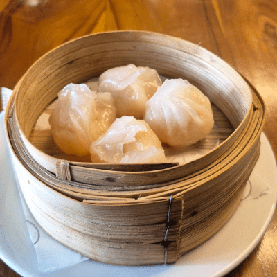 Steamed hakau shrimp dumplings in a bamboo basket