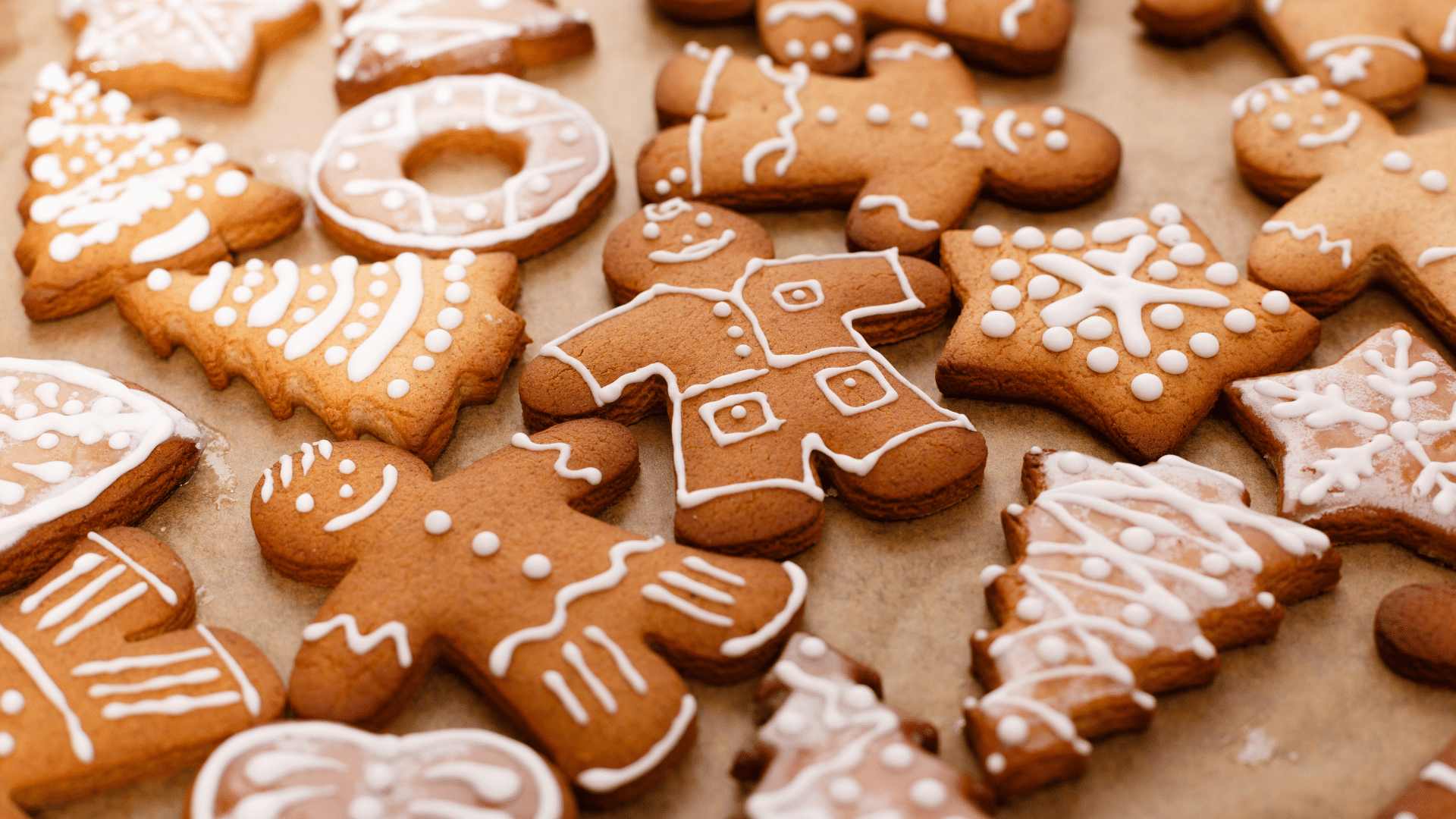 Warm gingerbread loaf with a spiced brown color, surrounded by gingerbread cookies and Christmas decorations.