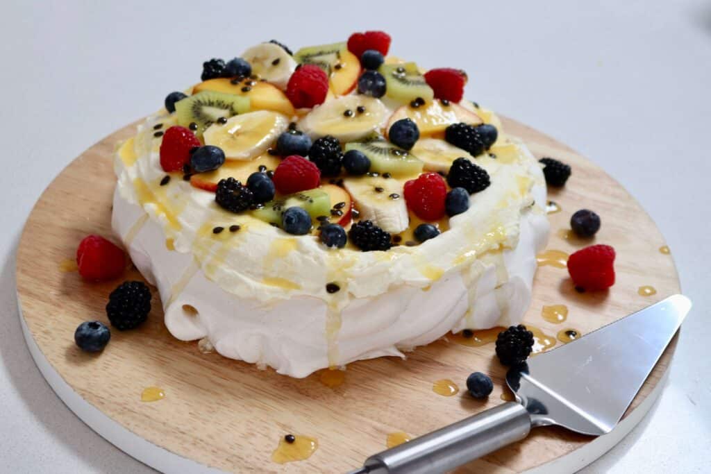 A classic Australian Pavlova topped with fresh berries and tropical fruits for Christmas.