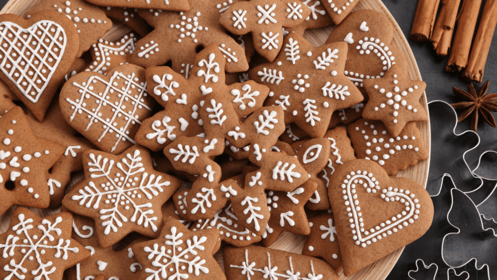 Traditional gingerbread cookies decorated with white icing and Christmas spices on a festive table