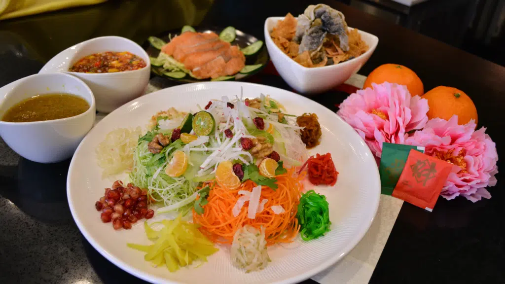 Yu Sheng Chinese New Year prosperity salad with salmon, vegetables, and plum sauce