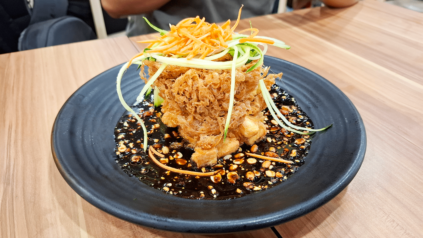 Tahu telur at Bebek Goreng Pak Ndut Singapore, crispy fried tofu and egg topped with savory sauce, ideal for sharing.