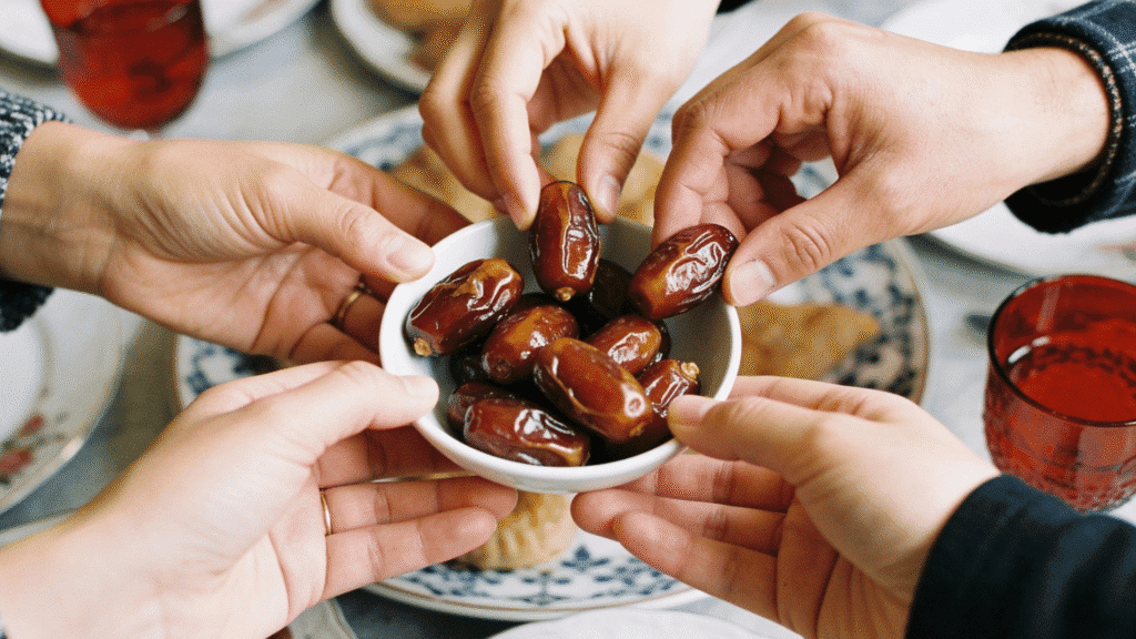 Person taking dates from a plate to break fast during Ramadan iftar