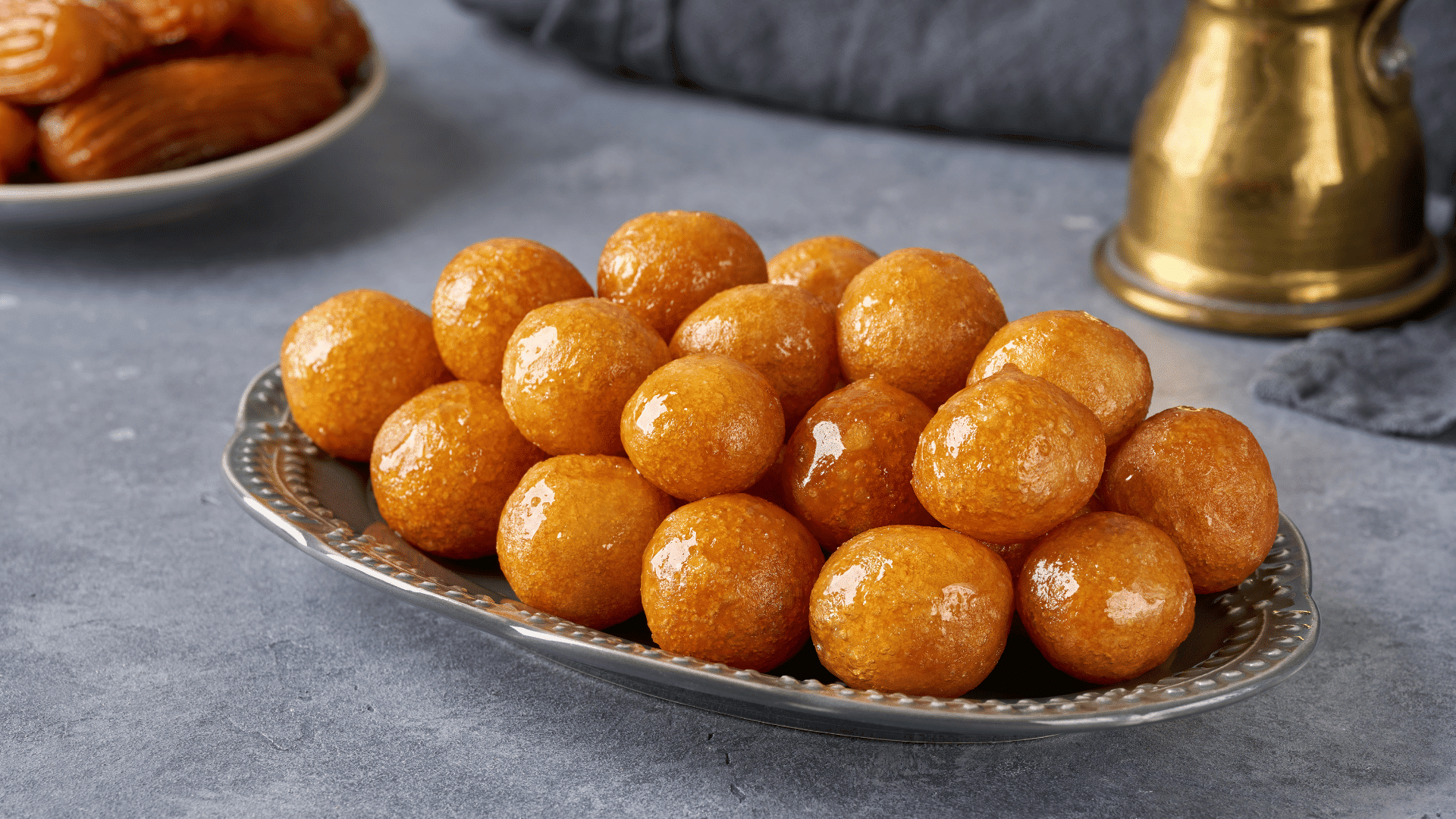 Golden luqaimat fried dough balls drizzled with date syrup, a popular Ramadan dessert in Gulf countries